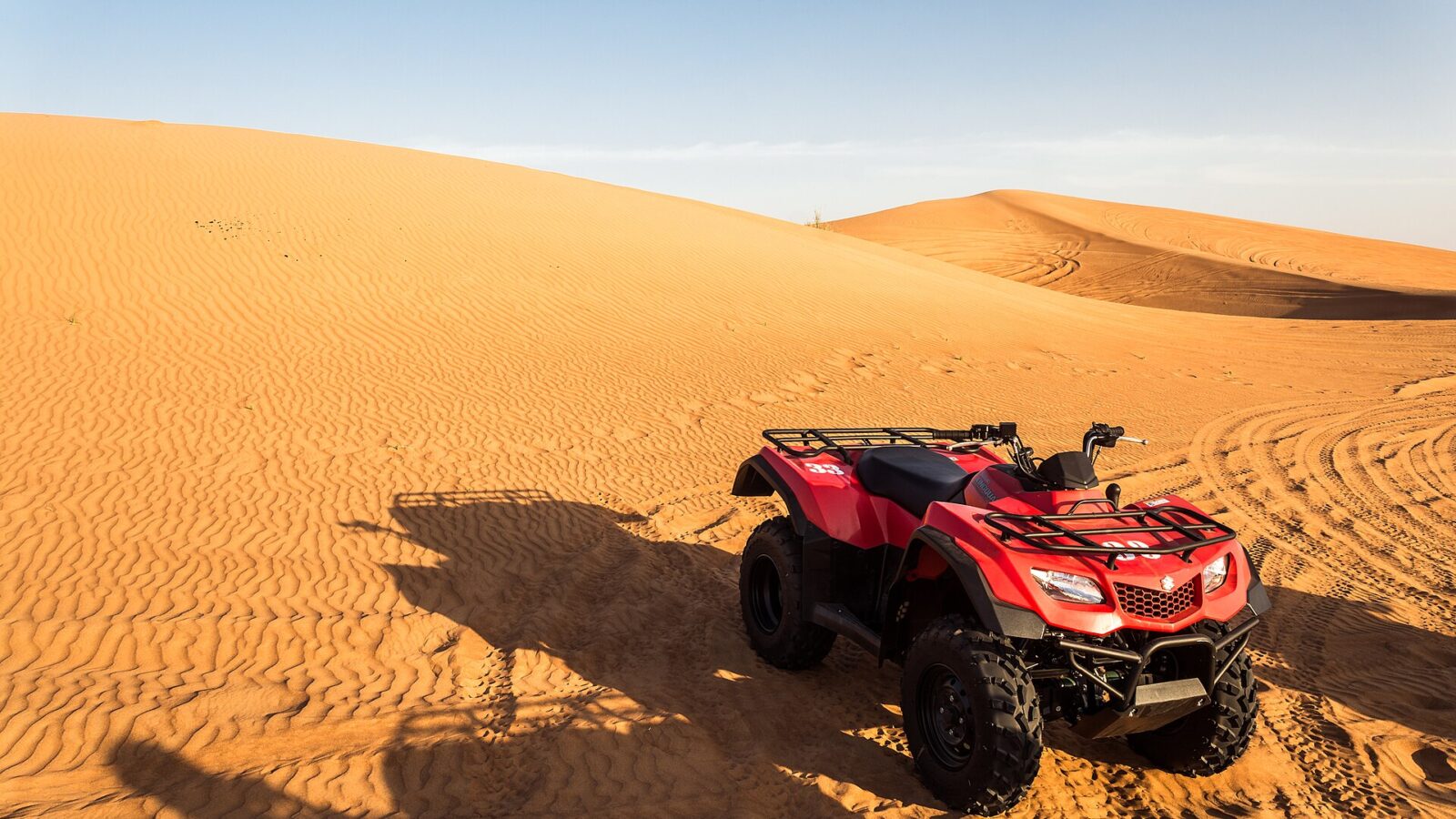 A quad bike parked on red dunes in the desert outside Dubai