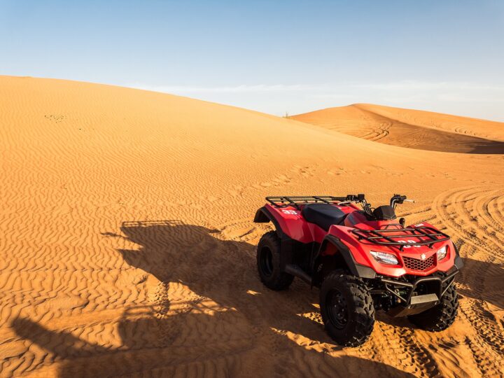 A quad bike parked on red dunes in the desert outside Dubai