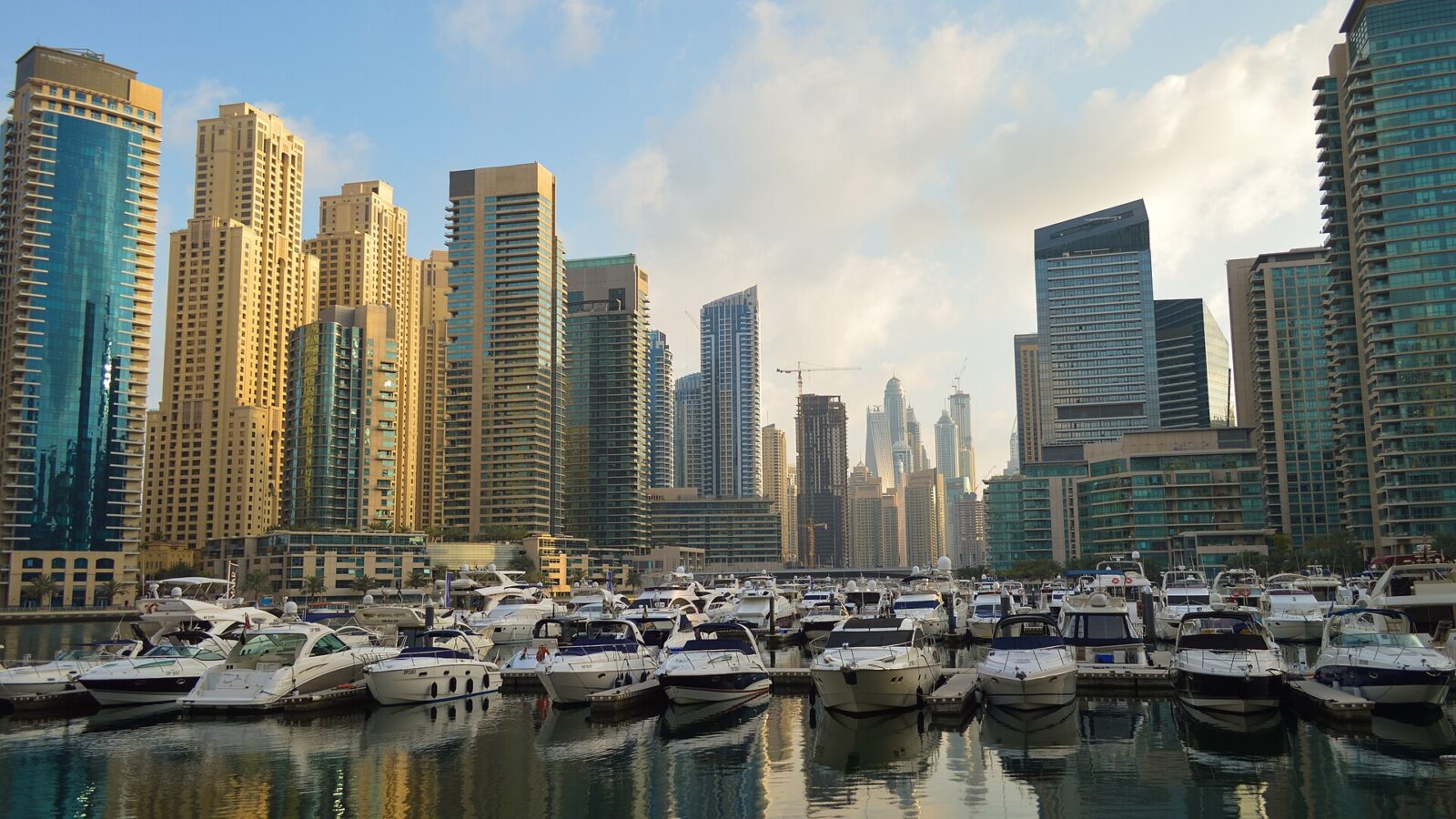 Boats moored in Dubai Marina with the towers behind them