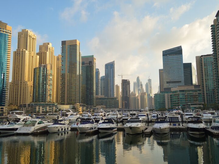 Boats moored in Dubai Marina with the towers behind them