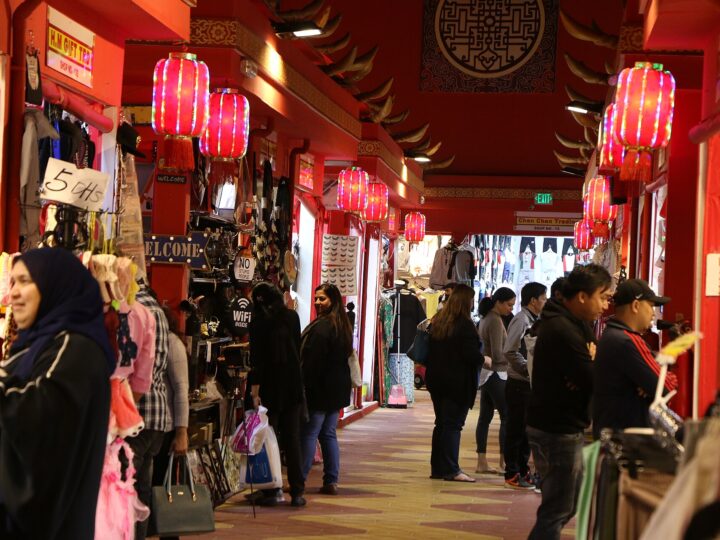 Shoppers in a lantern-lit pavilion lane at Global Village, Dubai